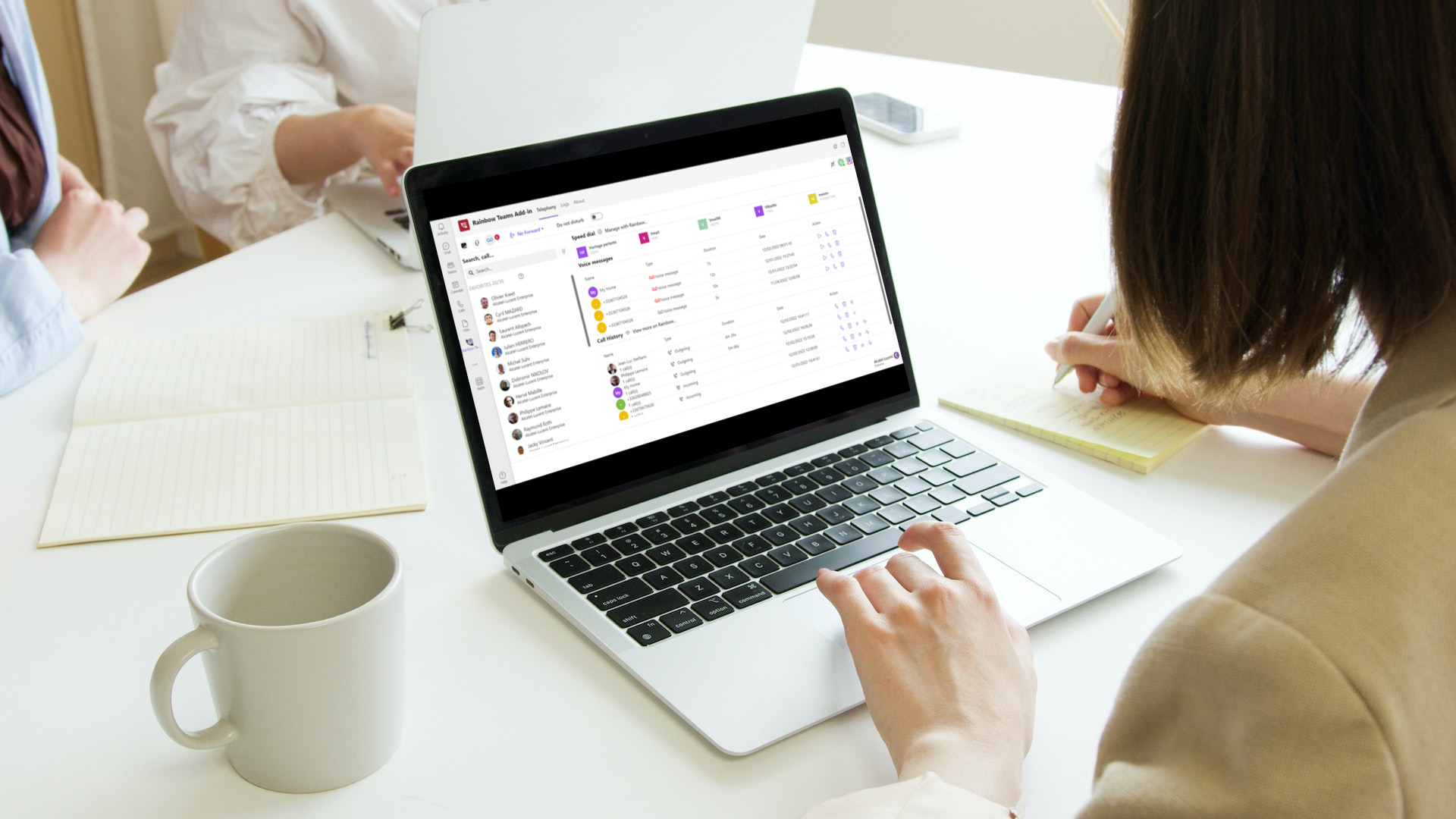 Woman taking notes aside from using the rainbow telephony for microsoft teams